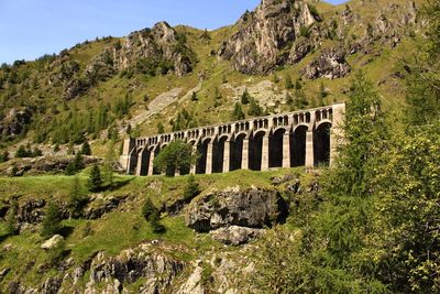 Arch bridge over mountains against sky