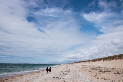 Plouhinec in brittany in france ,two people walking on the beach