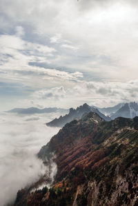 Scenic view of mountain range against cloudy sky