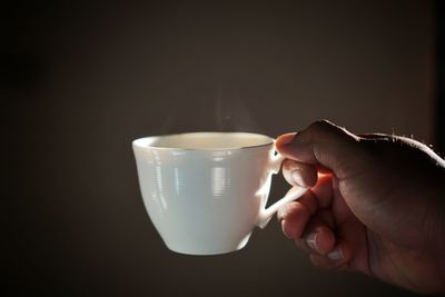 Close-up of hand holding coffee cup