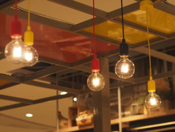 Illuminated light bulbs hanging in cafe