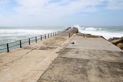 Pier on sea shore against sky