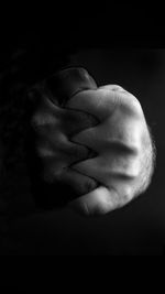 Close-up of human hand against black background