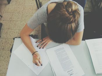 High angle view of girl writing at desk