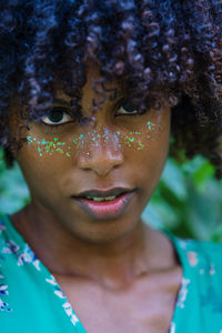 Portrait of a black woman with afro hair and glitter on her face