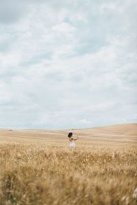 Man standing on field against sky