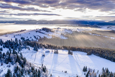 Scenic view of snow covered landscape against sky during sunset