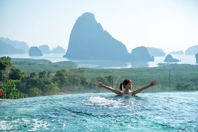 Man surfing in swimming pool against sea