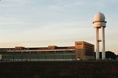 Air traffic control tower at tempelhof airport against sky during sunset