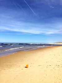 Scenic view of beach against blue sky