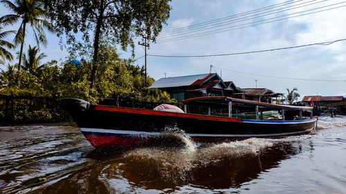 Boat moored in river against sky