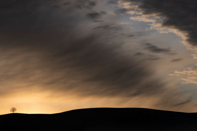 Low angle view of silhouette hill against sky during sunrise in switzerland.