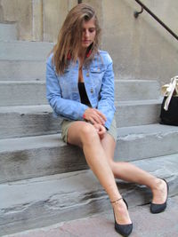 Young woman sitting on staircase