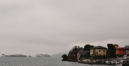 Buildings by sea against sky