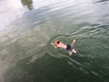 High angle view of boy swimming in lake