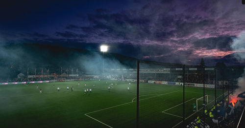 Group of people on soccer field against sky
