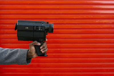 Close-up of man photographing with red camera