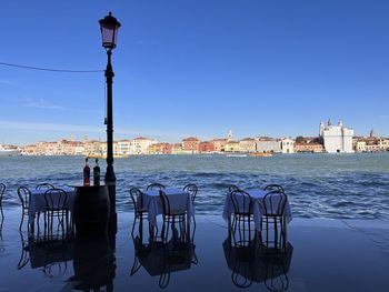 Reflection of tables standing in water of a high tide