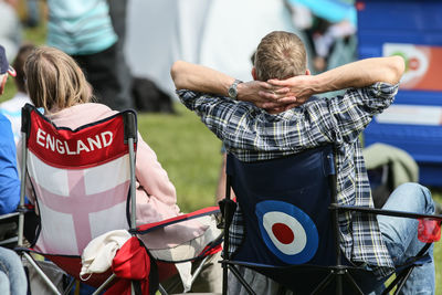 Rear view of people sitting on chairs