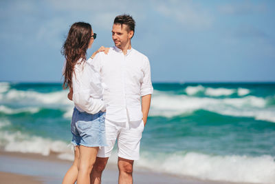 Rear view of couple standing at beach