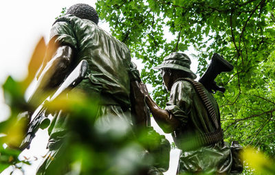 Low angle view of statue against trees