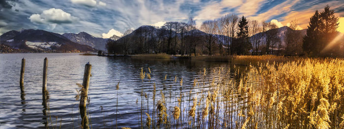 Scenic view of lake against snowy mountains and sky during sunset