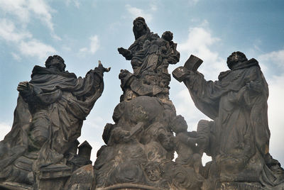 Low angle view of sculpture against cloudy sky