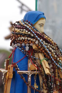 Low angle view of multi colored rosary beads on jesus christ