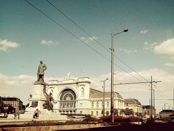 Statue of city against cloudy sky