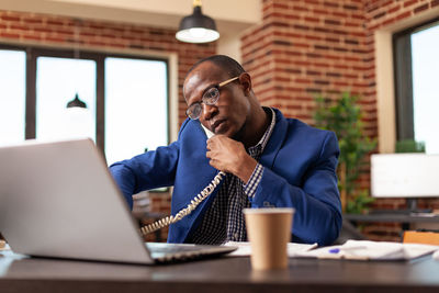 Businessman talking on phone at office