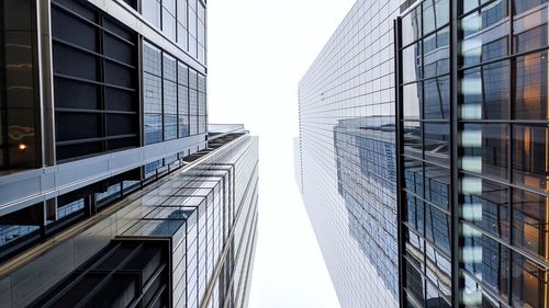 Low angle view of modern glass building against sky