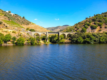 Arch bridge over river against sky