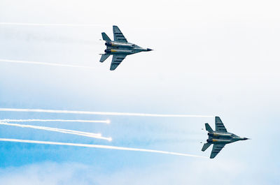 Low angle view of airplane flying against sky