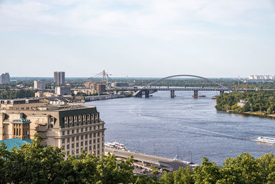 Urban cityscape and arched bridge structure across dnieper river