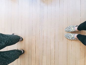 Low section of women walking on hardwood floor