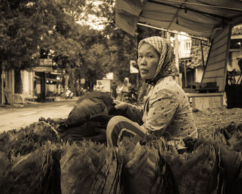 Side view portrait of female vendor selling leaves