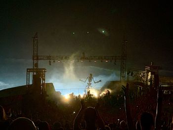 Panoramic view of crowd at music concert against sky at night