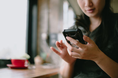 Midsection of woman using mobile phone