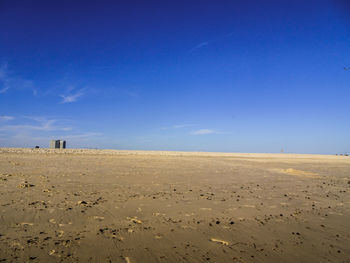 Scenic view of beach against blue sky