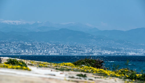 Scenic view of sea by city against sky