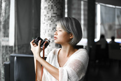 Woman holding smart phone at home