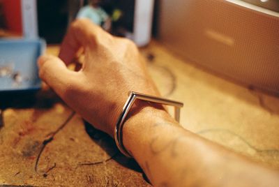 Close-up of man using mobile phone on table