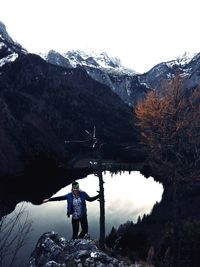 Rear view of man standing on mountain during winter