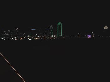 Illuminated cityscape against sky at night