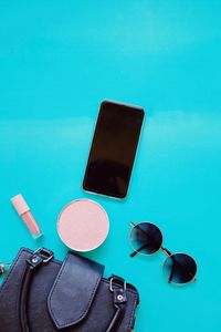 High angle view of sunglasses and laptop on blue background