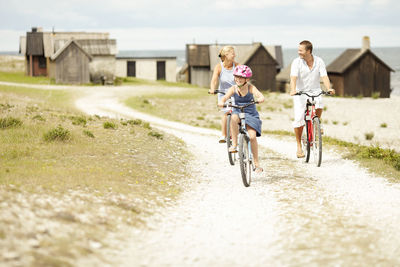 Rear view of people riding bicycle