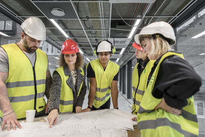 Workers reviewing blueprint at construction site