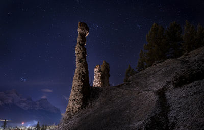 Low angle view of rock formation against sky at night