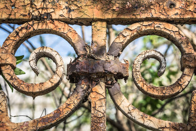 Low angle view of rusty wheel against sky