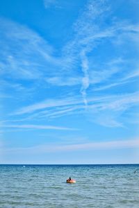 Person in sea against sky